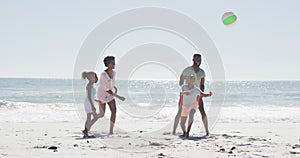 Happy african american family playing ball, having fun on beach