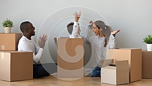Happy African American family playing with boxes in new apartment