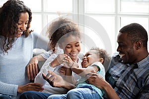 Happy African American family playing with children at home