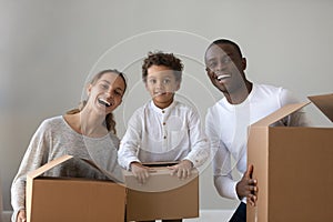 Happy african american family renters hold boxes looking at camera
