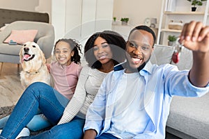 Happy African American family showing keys of their new apartment