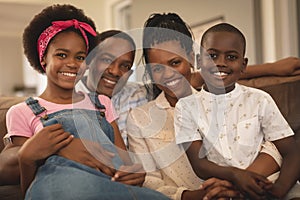 Happy African American family sitting on the sofa and looking at camera