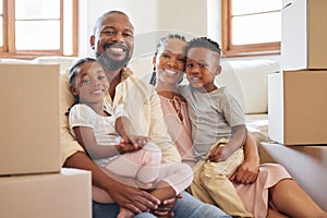Happy african american family smiling while sitting on the floor in a new home. Portrait of a young happy black couple
