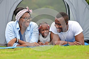 Happy African American family spending time together during vacation on the camping tent outdoor park