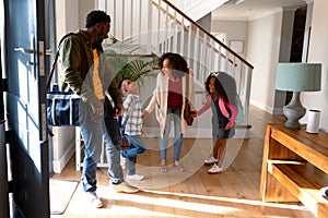 Happy african american family standing in hallway, returning back home