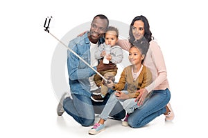 happy african american family with two kids taking selfie with smartphone