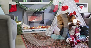 Happy african american father with daughter playing with snow globe