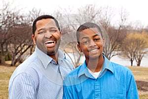 Happy African American father and son talking and laughing.