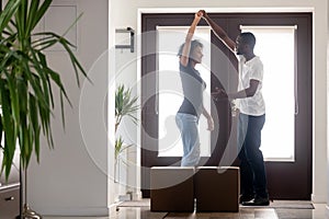 African couple dancing in hallway moving into new home
