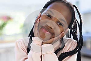 Happy african american girl with hands on face at home, close up, copy space