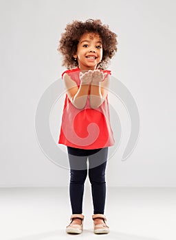 Happy african american girl holding something