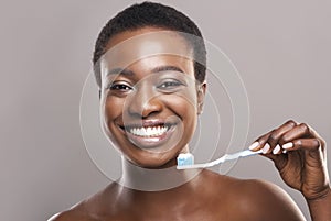 Happy african american girl holding toothbrush with applied toothpaste