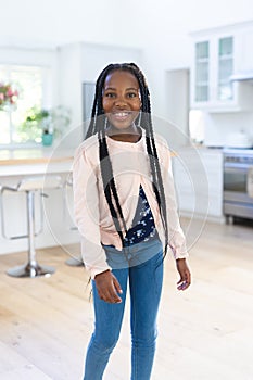 Happy african american girl standing at home, copy space