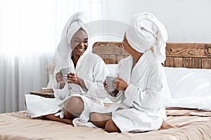 Happy women drinking coffee and talking after shower