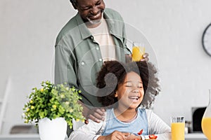 happy african american grandparent holding glass