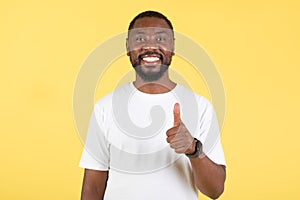 Happy African American Guy Gesturing Thumbs Up Posing, Yellow Background