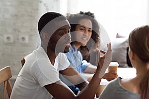 Happy african american guy talking to friends.