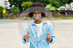 Happy african american hipster young adult showing thumbs up