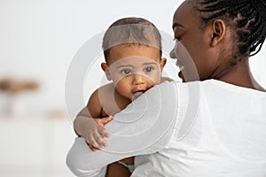 Happy African American lady hugging her cute child