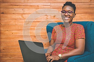 Happy African-American Lady working with laptop at home