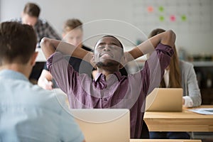 Happy african american leaning in chair in office