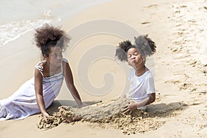 Happy african american Little girl play and  buried in sand on the beach