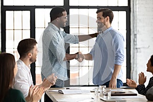 Happy African American male boss welcoming new hired employee