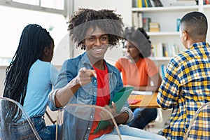 Happy african american male college student at desk at classroom