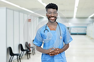 Happy african american male nurse at vaccination station is ready for vacinating patients against coronavirus infection