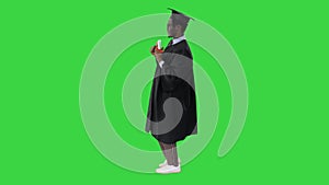 Happy african american male student in graduation robe posing with diploma for camera on a Green Screen, Chroma Key.