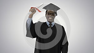 Happy african american male student in graduation robe walking t