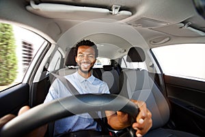 Happy african american man with beard driving car