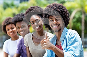 Happy african american man with group of young adults in line