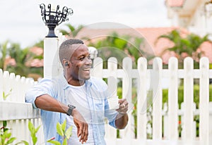 Happy african american man holding paper glass and laughing at outdoor