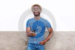 Happy african american man listening to music with cellphone and earphones