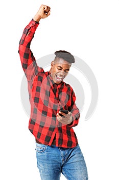 Happy african american man looking at phone and cheering with arm raised