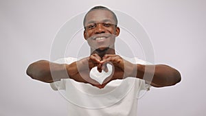 Happy african american man making heart shape sign with hands looking at camera.