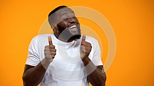 Happy African-American man rejoicing and showing thumbs-up, best life moments