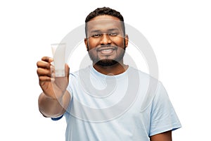 Happy african american man showing moisturizer