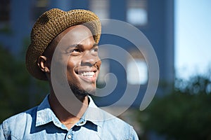 Happy african american man smiling outdoors with hat