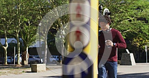 Happy african american man using smartphone, drinking coffee, crossing street wearing backpack