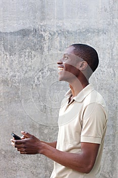 Happy african american man walking with mobile phone