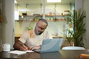 Happy African American man wearing casual clothes working in his home