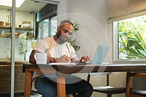 Happy African American man wearing casual clothes working in his home