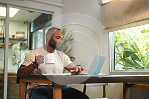 Happy African American man wearing casual clothes working in his home