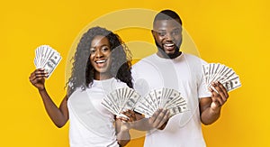 Happy african-american man and woman holding dollars