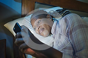 Happy African American millennial woman as social media addict - night lifestyle portrait of young beautiful and cool black girl