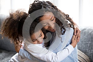 Happy African American mom and daughter hug making peace