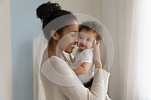 Happy African American mom embrace little baby toddler