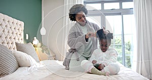 Happy african american mother combing hair of daughter using smartphone in bedroom, slow motion